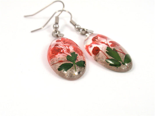 Oval resin earrings containing red babys breath with green leaves and silver hooks