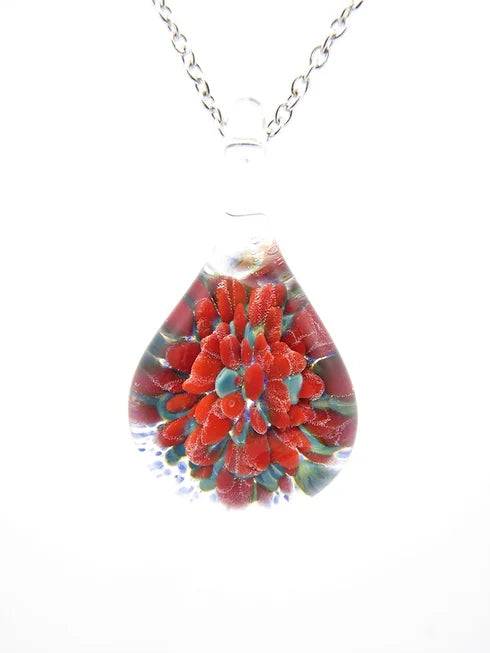 Teardrop glass pendant featuring a red marigold bloom encased in cremation ashes on a silver chain