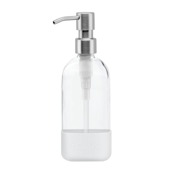 The Refillable Dish Soap Dispenser by Grove Co. features a clear glass body with a stainless steel pump, encased in a white silicone sleeve embossed with Grove Co. Its minimalist design is perfect for eco-friendly homes reducing plastic waste.