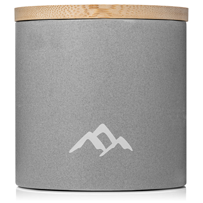 A gray cylindrical container with a wooden lid contains the DEET-free Refillable Mosquito Repellent Candle by Murphys Naturals, featuring a minimalist white mountain logo and an essential oil blend for pest-free relaxation.