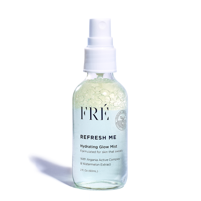 Displayed against a white backdrop, the clear spray bottle, labeled FRÉ Skincare REFRESH ME Toning Glow Mist, shows bubbles inside. It highlights Argania Active Complex & Watermelon Extract and contains 2 fl oz (60 mL), making it an ideal addition to any skincare routine.