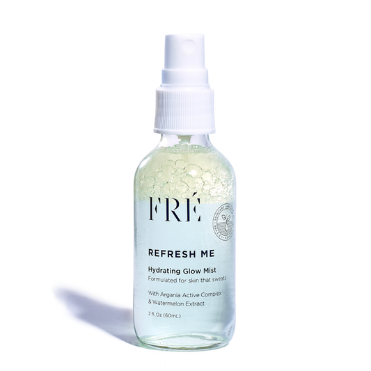 Displayed against a white backdrop, the clear spray bottle, labeled FRÉ Skincare REFRESH ME Toning Glow Mist, shows bubbles inside. It highlights Argania Active Complex & Watermelon Extract and contains 2 fl oz (60 mL), making it an ideal addition to any skincare routine.