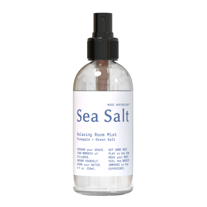 The Muse Apothecary: Relaxing Room Mist spray bottle provides an aromatherapeutic experience with scents of pineapple and ocean salt, contains 8 fluid ounces (236 mL), and has a sleek black spray nozzle.