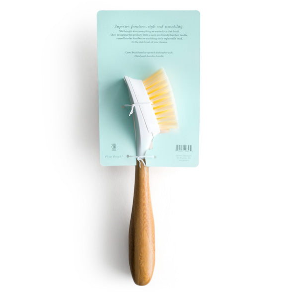 The Replaceable Head Bristle Dish Brush by Grove Co. features a bamboo handle and curved white bristles, mounted on a light blue cardboard backing with product information.