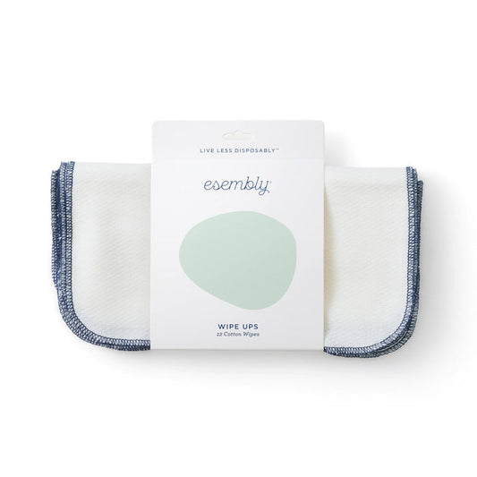 The package of Esembly Babys Reusable Wipes, featuring a pale green circle, displays Wipe Ups and includes 12 certified unbleached 100% organic cotton wipes. These are perfect for sustainable cleaning with their white fabric and blue trim.