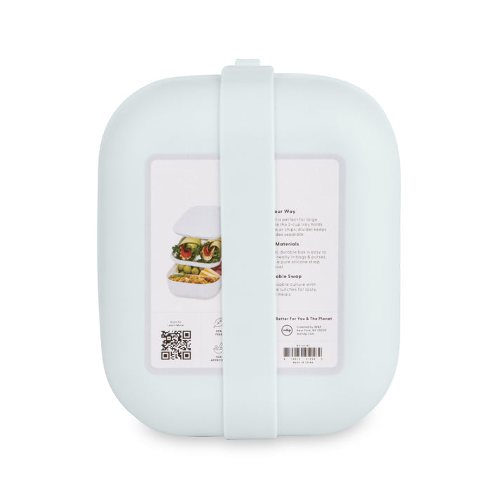 The W&P Reusable Bento Box is a light teal, rectangular container with rounded corners and a band. It features a label with packed food images and text, has multiple compartments for organization, and includes a QR code on the label.