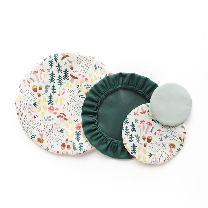 Explore Esembly Babys Bowl Caps: a set of four round food covers with forest-themed designs, crafted from recycled plastic. They include three elastic-edged covers and one plain light green. These washable caps offer various sizes for easy use and cleaning!.