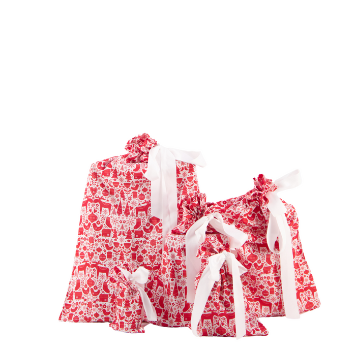 Five Reusable Gift Bags by Waste Free Celebrations, crafted from 100% cotton in red and white patterns with drawstrings, are set against a white background. Each bag is finished with a charming white ribbon bow, providing sustainable gift wrap options for various occasions.