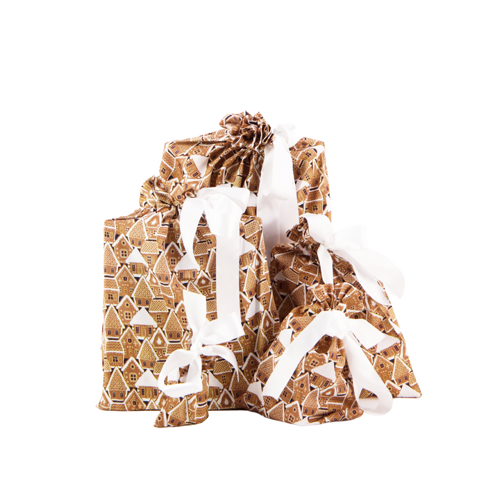 The Reusable Gift Bags by Waste Free Celebrations come in a set of five, showcasing a gingerbread house design with white ribbons on a clean white background—ideal for eco-friendly and elegant gift wrapping.