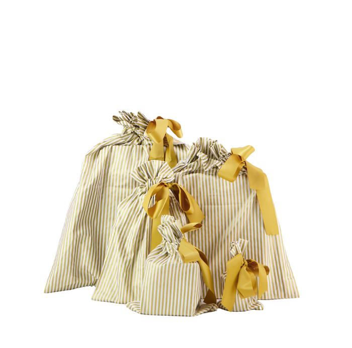 Five striped, drawstring bags from Waste Free Celebrations, made of 100% cotton with thin vertical yellow stripes and tied with yellow ribbons, create a charming layered effect as sustainable gift wrap in varying sizes from small to large.