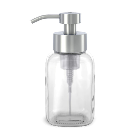The Reusable Glass Foaming Hand Soap Dispenser by Grove Co. is a modern, sleek, transparent glass bottle with a silver pump and spout. Ideal for foaming soap, this reusable dispenser helps reduce plastic waste and is photographed empty against a white backdrop.