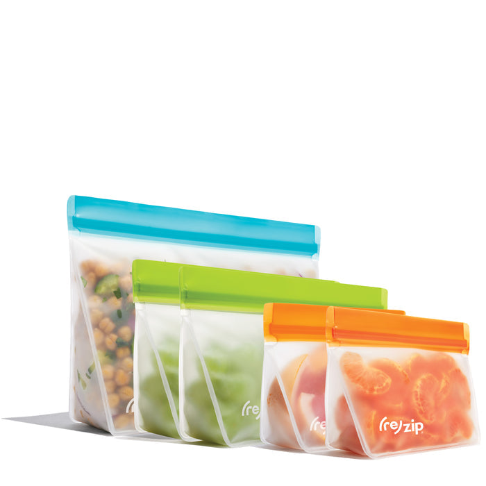 The (re)zip Reusable Leakproof Bags Stand-Up Starter Kit includes four freezer-safe bags in blue, green, yellow, and orange, displayed in a row with food inside—perfect for organizing your kitchen.