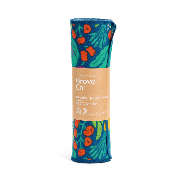 A roll of Grove Co. Reusable “Paper” Towels, made from machine-washable organic cotton flannel, features a red cherry and green leaf pattern on a blue background and is wrapped in a brown paper label.