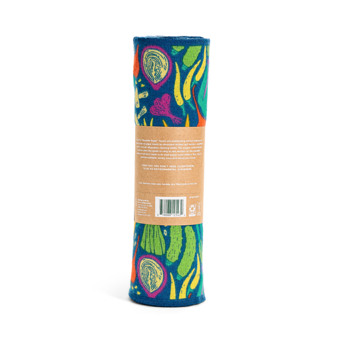 The Grove Co. Reusable Paper Towel, crafted from organic cotton flannel, features a colorful abstract pattern with green, yellow, and pink shapes on dark blue. A brown paper label shows product details and a barcode. Enjoy its machine-washable convenience.