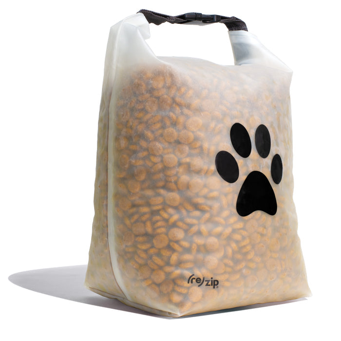 The (re)zip Reusable Pet Food Storage Bag - Large, 40 Cup, is a translucent, airtight bag with a black zip closure and paw print design. It stands upright and is filled with brown pet kibble.