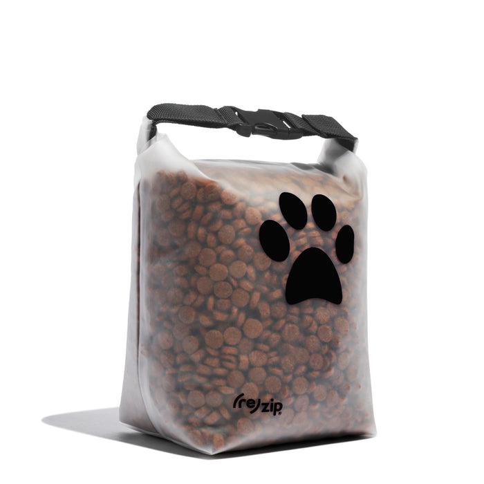 A reusable, transparent (re)zip Pet Food Storage Bag - Medium, 14 Cup, filled with brown kibble. The bag has a black paw print design, black clip closure at the top, and is perfect for portable pet food storage.