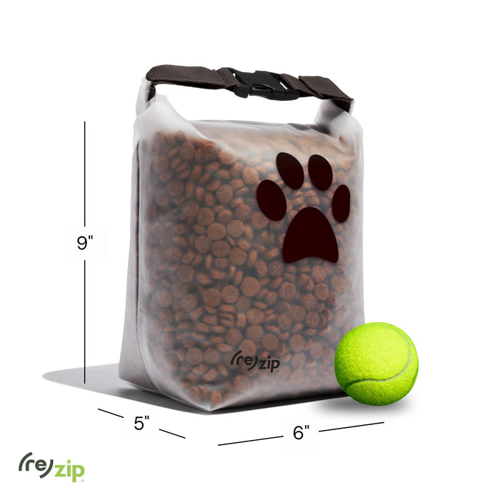 A (re)zip Reusable Pet Food Storage Bag - Medium, 14 Cup, featuring a brown paw print design and filled with kibble, is displayed beside a yellow tennis ball for size reference. Bag measures 9" tall, 6" wide, and 5" deep.