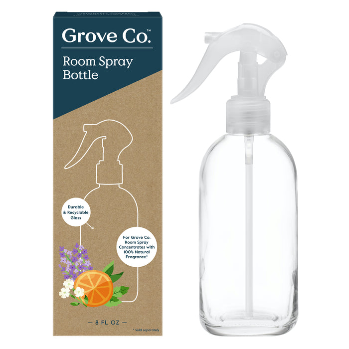 Photo of Grove Co. Reusable Room Spray Bottle and packaging. The box showcases this eco-friendly option with flower and orange slice illustrations, emphasizing the glass bottles recyclability and durability. The clear bottle has a white spray nozzle for convenient reuse.
