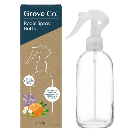 Photo of Grove Co. Reusable Room Spray Bottle and packaging. The box showcases this eco-friendly option with flower and orange slice illustrations, emphasizing the glass bottles recyclability and durability. The clear bottle has a white spray nozzle for convenient reuse.