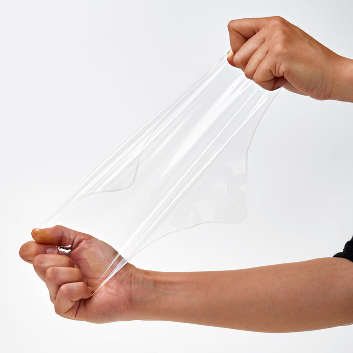 Two hands stretch W&Ps Reusable Silicone Stretch Wrap over a plain white background. The flexible, glossy silicone provides an eco-friendly alternative to plastic for reusable kitchen use.