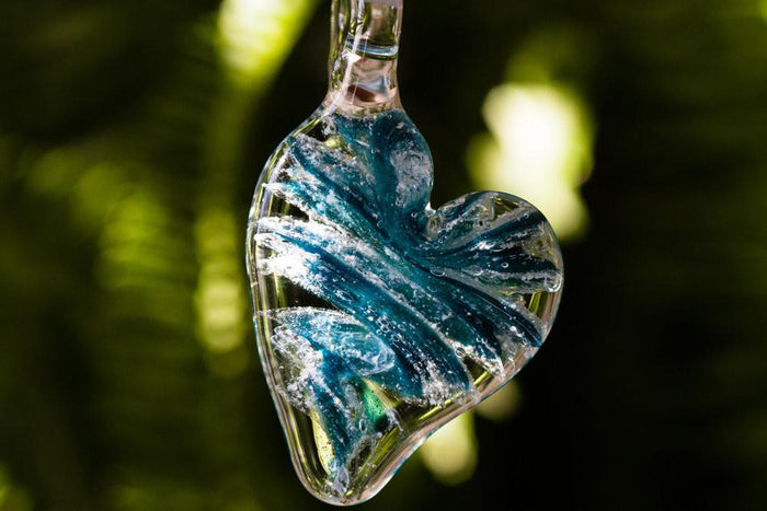 Ripple Heart Necklace pendant infused with cremation ashes featuring blue and yellow swirls inside a clear glass heart