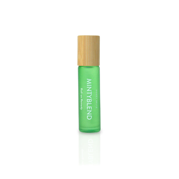 A green glass roll-on bottle labeled Minty Blend features a wooden cap, embodying the charm of essential oils. Branded as Honey Belles Roll-on Remedy, it suggests soothing aromatherapy power. The upright bottle on a white background immediately evokes tranquility.
