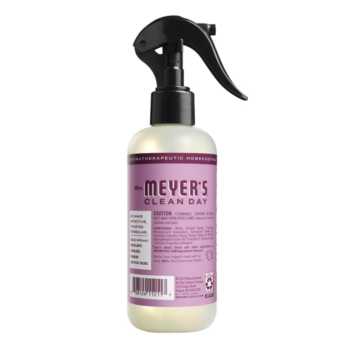A spray bottle of Mrs. Meyers Room Freshener with a purple label and essential oils for a refreshing clean, featuring a black trigger spray nozzle designed for versatile cleaning.