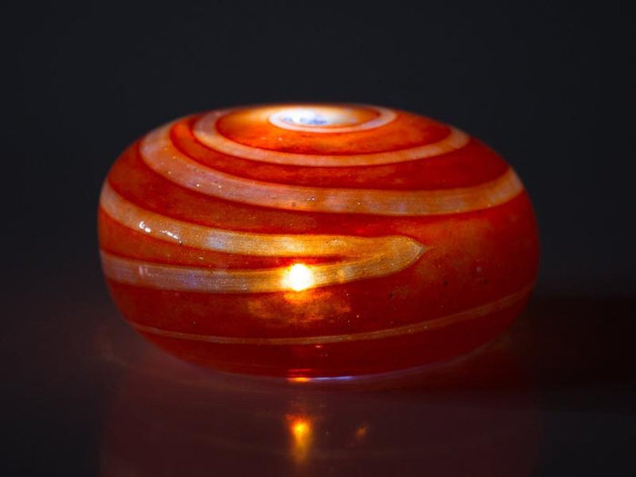 Rose red swirl votive memorial stone glowing from within with concentric ring patterns