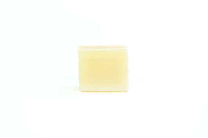 The Rosemary Mint Shampoo Bar from Spinster Sisters Co. is centered against a white background, embodying a plastic-free skincare solution.