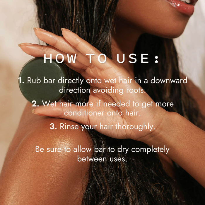 A woman with wet hair uses the Good Juju Body & Home Scalp Care Conditioner Bar, following directions to rub it onto her hair, reapply as needed, and rinse thoroughly for effective scalp care.