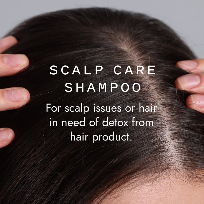 Close-up of a person parting dark hair reveals their scalp. Overlaid text: Good Juju Body & Home Scalp Care Conditioner Bar—for dandruff relief or detoxing product build-up—use with our Scalp Care Shampoo for best results.
