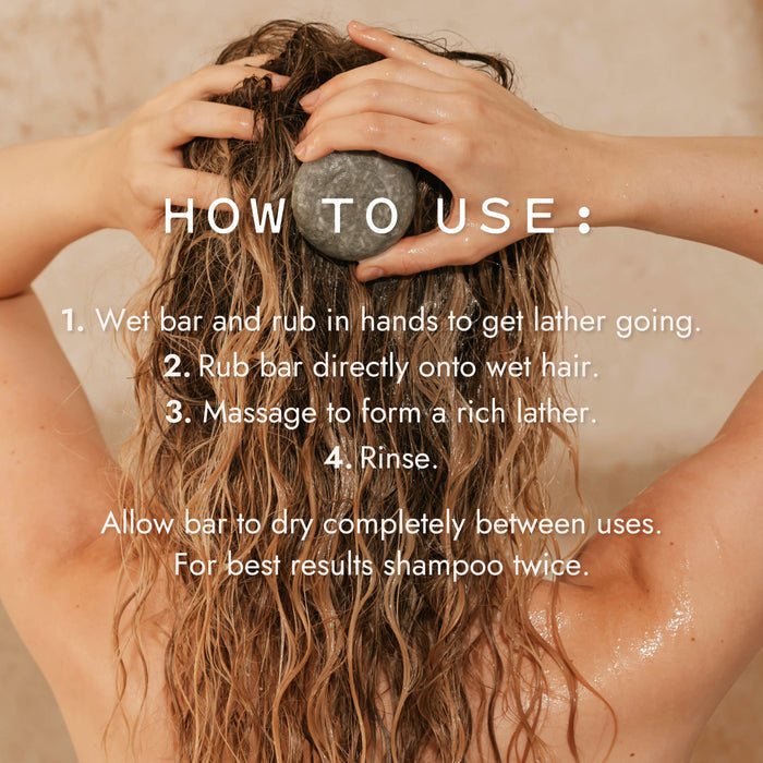 A person with wet, wavy hair massages Good Juju Body & Home’s Scalp Care Conditioner Bar onto their head for dandruff relief. Text overlays provide step-by-step usage instructions against a soft, neutral backdrop.