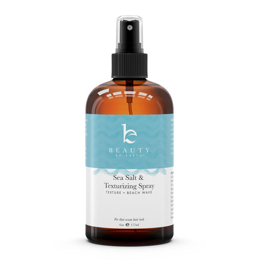 A brown spray bottle labeled Sea Salt Spray Hair Texturizer by Beauty by Earth features a turquoise wave-patterned label. This 6 oz (177 ml) spray is perfect for achieving effortless beach waves.