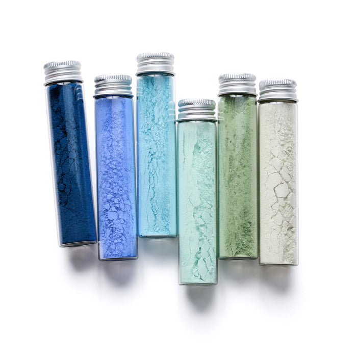 The elseware Sea & Sky Paint Set includes six glass vials with metal caps featuring earth-friendly, non-toxic pigments in shades of blue, green, and white. Each color is unique and showcases a vibrant display reminiscent of sea and sky hues.