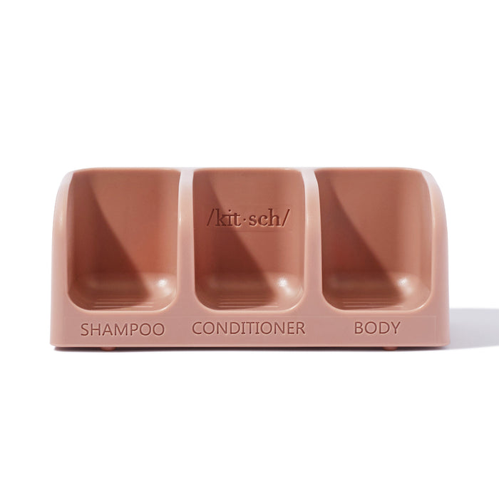 A beige organizer by Kitsch, embracing the Bottle-Free Beauty ethos, features a self-draining design with three compartments labeled Shampoo, Conditioner, and Body.