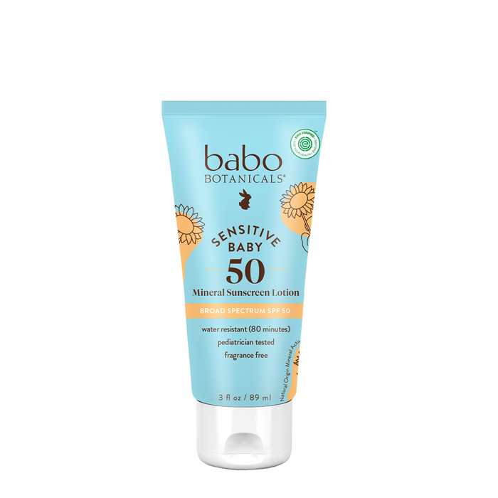 A tube of Babo Botanicals Sensitive Baby Mineral Sunscreen Lotion SPF50, featuring a light blue label with orange accents, is broad spectrum, water resistant, fragrance-free, and pediatrician tested.