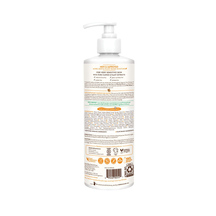 Back view of a Babo Botanicals Sensitive Baby Shampoo & Wash bottle featuring a pump dispenser. Designed for sensitive baby skin, the label shares product details, usage instructions, and an ingredient list. The white bottle with orange and brown text showcases logos and icons at the bottom.