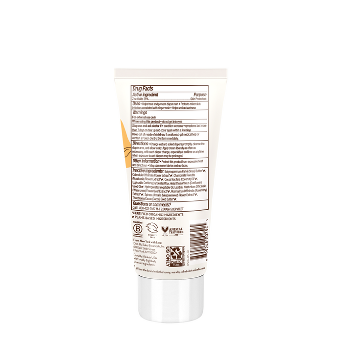 The back of a white tube of Babo Botanicals Sensitive Baby Zinc Diaper Rash Cream lists drug facts, directions, plant-based ingredients, warnings, certifications, and a barcode. A silver cap accents the mainly black and brown label for babys delicate skin.