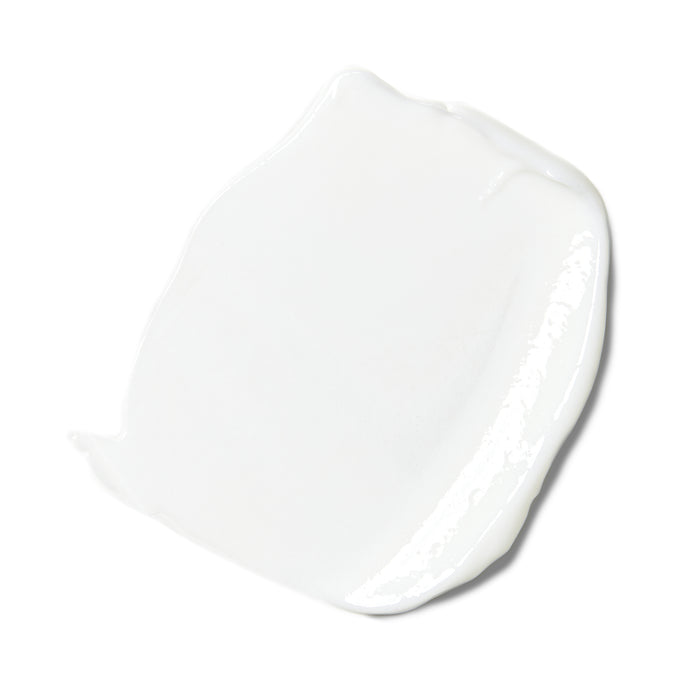 A smear of thick, glossy white cream with a smooth, shiny texture on a plain white background—a soothing Sensitive Skin Daily Moisturizer by Rooted Beauty that’s EWG VERIFIED™ for ultimate reassurance.