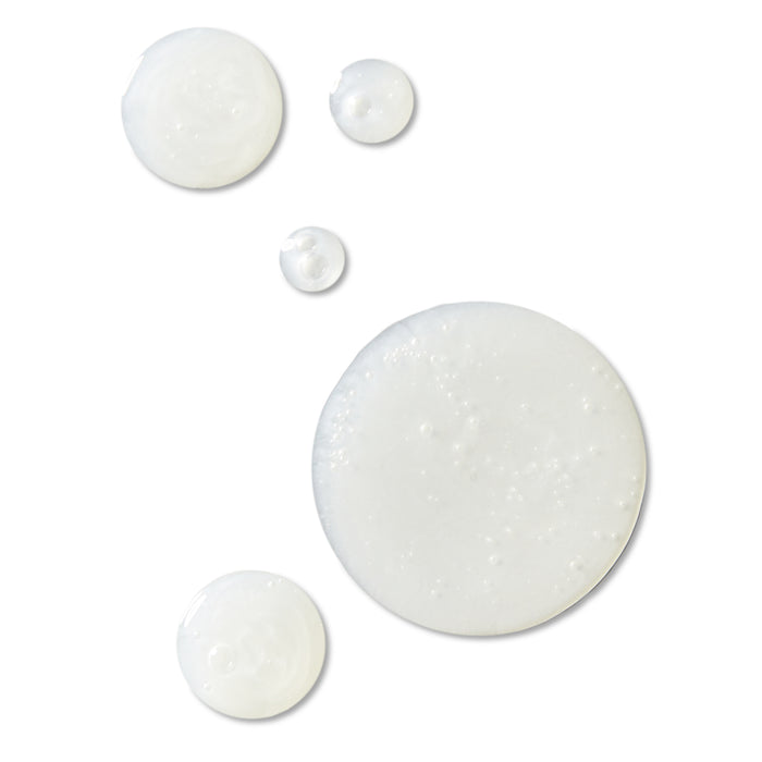 On a pristine background, five circles of white liquid from Rooted Beautys Sensitive Skin Facial Cleanser vary in size. Their glossy texture and scattered bubbles evoke the smooth feel of skincare products, possibly in recyclable packaging.