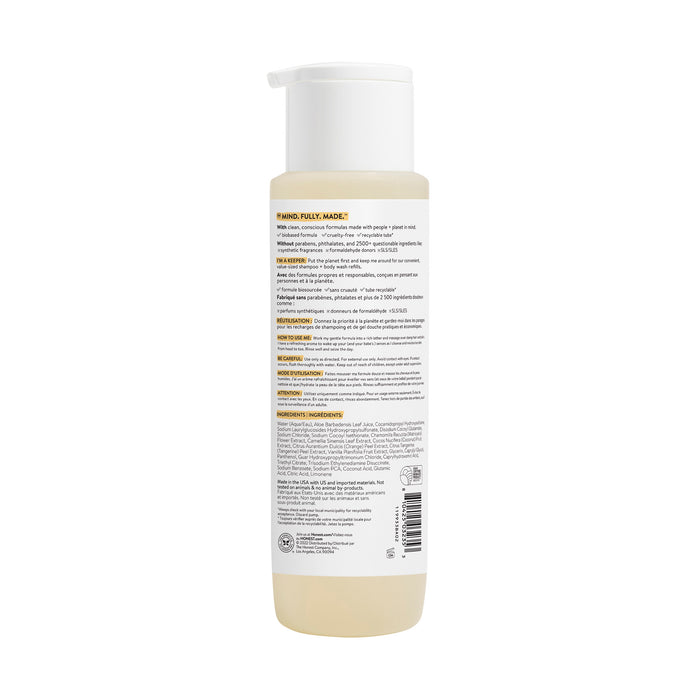 The Honest Companys Shampoo + Body Wash comes in a clear bottle with a white pump, containing light yellow liquid enriched with chamomile extract. The back label has detailed info and instructions. Its sleek, simple design adds elegance to your bathroom shelf.