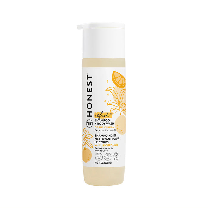 A 10 fl oz (295 mL) bottle of The Honest Company Shampoo + Body Wash features a refreshing citrus vanilla scent, charming citrus fruits and leaves on a white and beige design with English and French text, enriched with Aloe + Chamomile Extract.