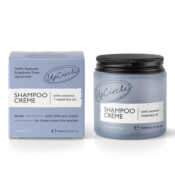 A 100ml blue jar and box of UpCircles sulfate-free Shampoo Crème, featuring coconut and grapefruit oil, labeled as 100% natural. This Shampoo Revolution product highlights natural ingredients in a compact container.