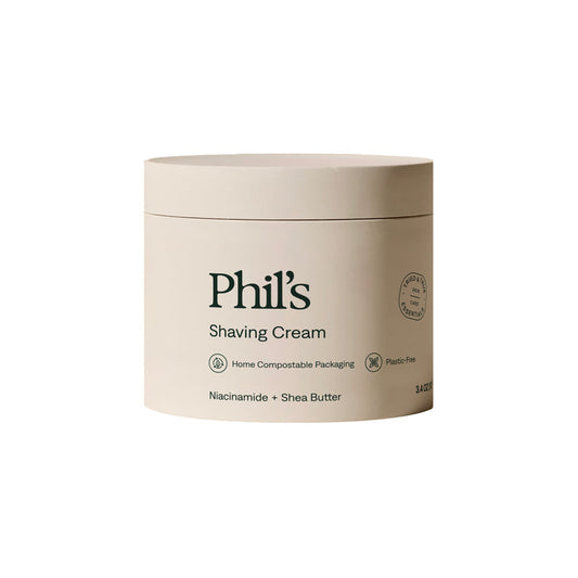 Phil's Shaving Cream comes in a beige, plastic-free, home compostable 3.4 oz container with green text. It features niacinamide and moisturizing shea butter for a luxurious shave.