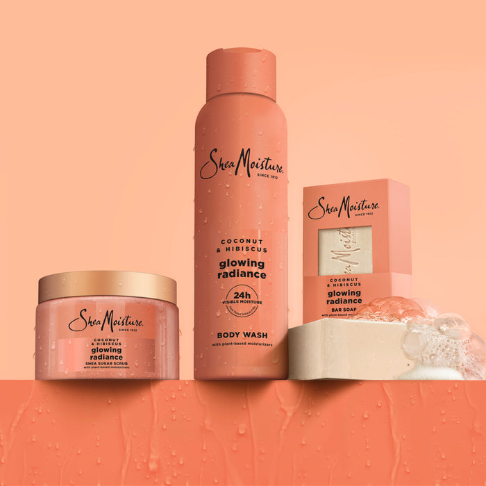 SheaMoisture Shea Butter Bar Soap, along with other Glowing Radiance products, is beautifully displayed on an orange background with water droplets—specially crafted for melanin-rich skin and brightening dull skin.