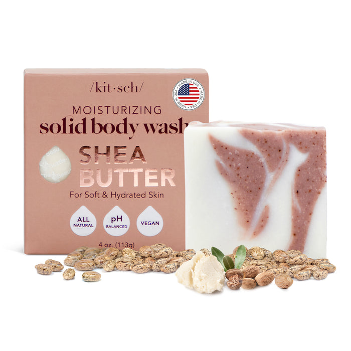 A solid body wash bar labeled Shea Butter Moisturizing from Kitsch stands beside its box. With a super-hydrating formula, the packaging highlights All Natural, pH Balanced, and Vegan. Scattered shea butter and nuts visually emphasize its skin-moisturizing benefits effectively.
