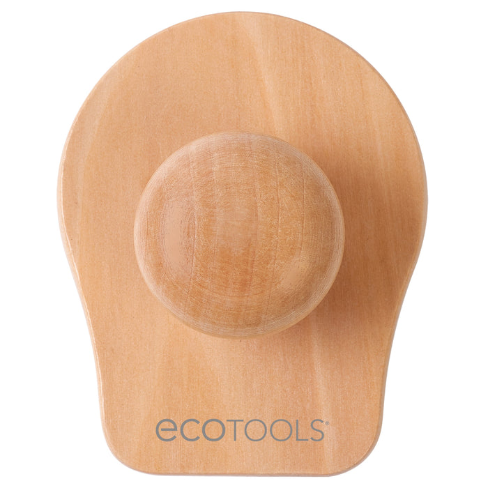 The EcoTools Shower Scalp Massager is a wooden tool with a smooth finish, featuring a rounded handle and oval base. The EcoTools logo is printed on the base, designed for deep cleansing and promoting hair growth.