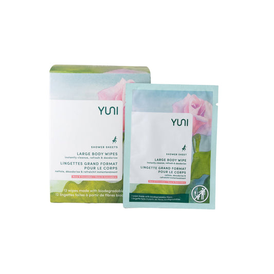 YUNI Shower Sheets are packaged for on-the-go use in a mostly white box with floral graphics and green accents. The design features bilingual English and French text and prominently displays an individual shower sheet packet.