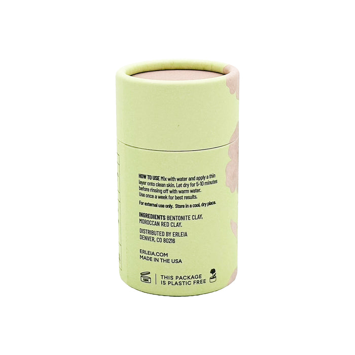 A cylindrical container with a light green label features Erleias Signature Clay Mask, complete with usage instructions and ingredients like bentonite and Moroccan red clay. It includes environmental details and is proudly made in the USA.