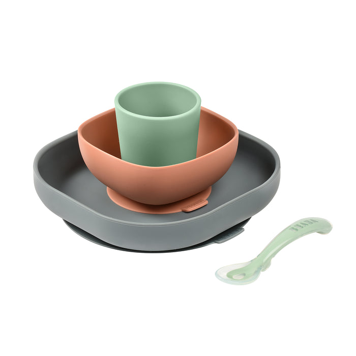 Discover the BEABA Silicone Baby Feeding Set, a BPA-free dinnerware collection featuring a gray plate, brown bowl, green cup, and a spoon with a light green transparent handle. Ideal for toddler feeding, these stackable items offer a compact design.